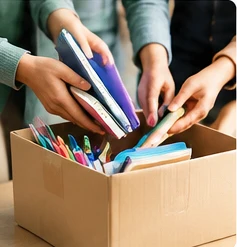 Mãos a organizar materiais escolares para doação, imagem ilustrativa